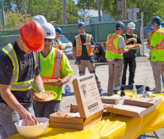 Workers grab chips and pizza for lunch.